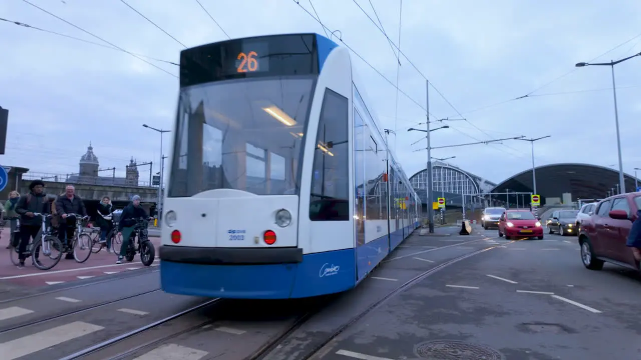 Modern tram in Amsterdam with cyclists and pedestrians on a typical city street