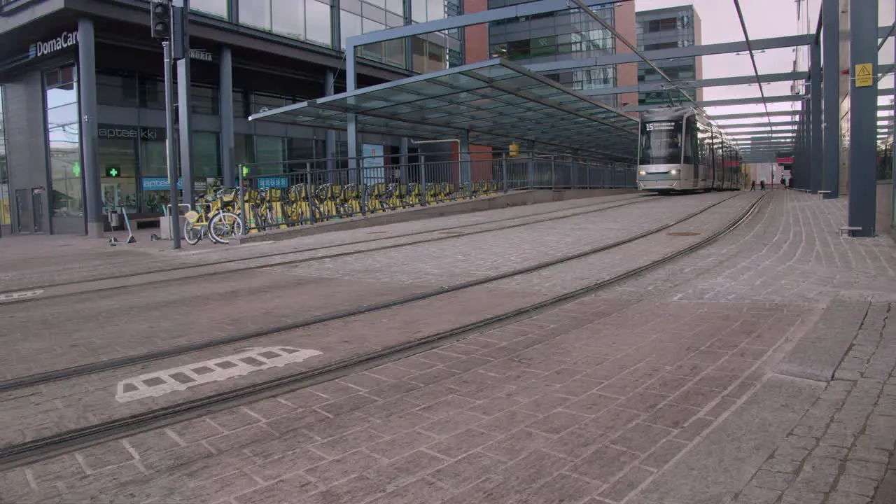 Quiet Helsinki street scene transit train arrives at cobbled station