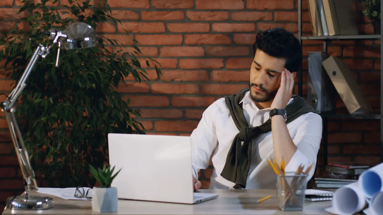 Tired Arabian Businessman Doing His Job At The Laptop Computer And Looking Bored In The Office