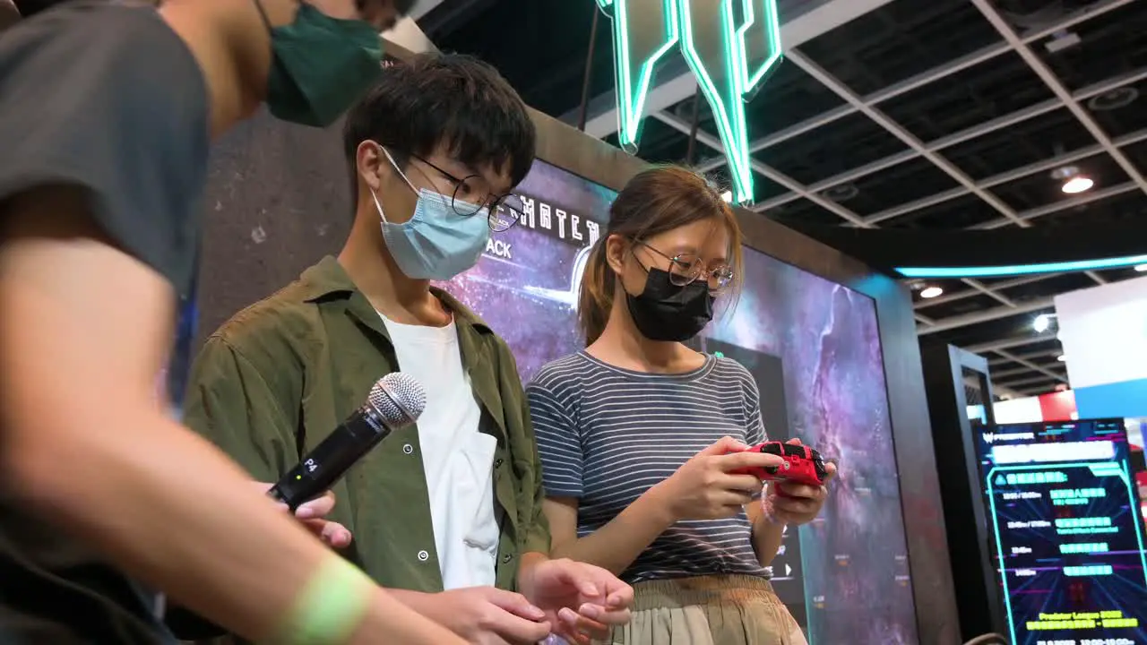 Chinese gamers and visitors play video games at an exhibitor's booth during the Hong Kong Computer and Communications Festival in Hong Kong