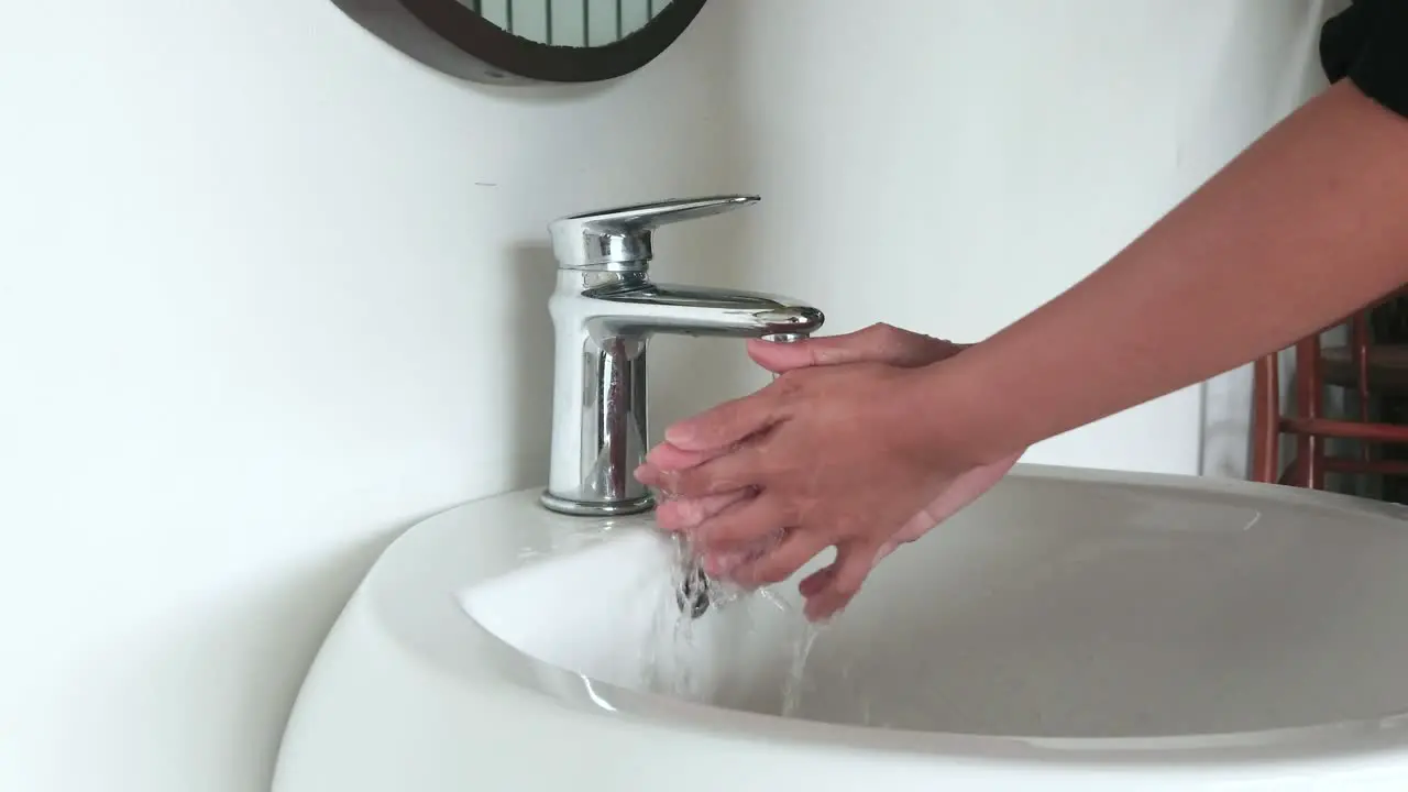 Washing hand in a sink to wash the skin and water flows through the hands