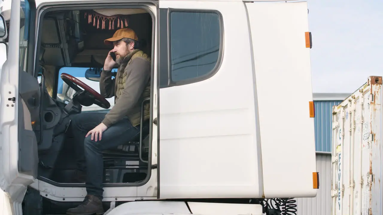 Worker Wearing Vest And Cap Organizing A Truck Fleet In A Logistics Park While Talking On The Phone In A Truck 1