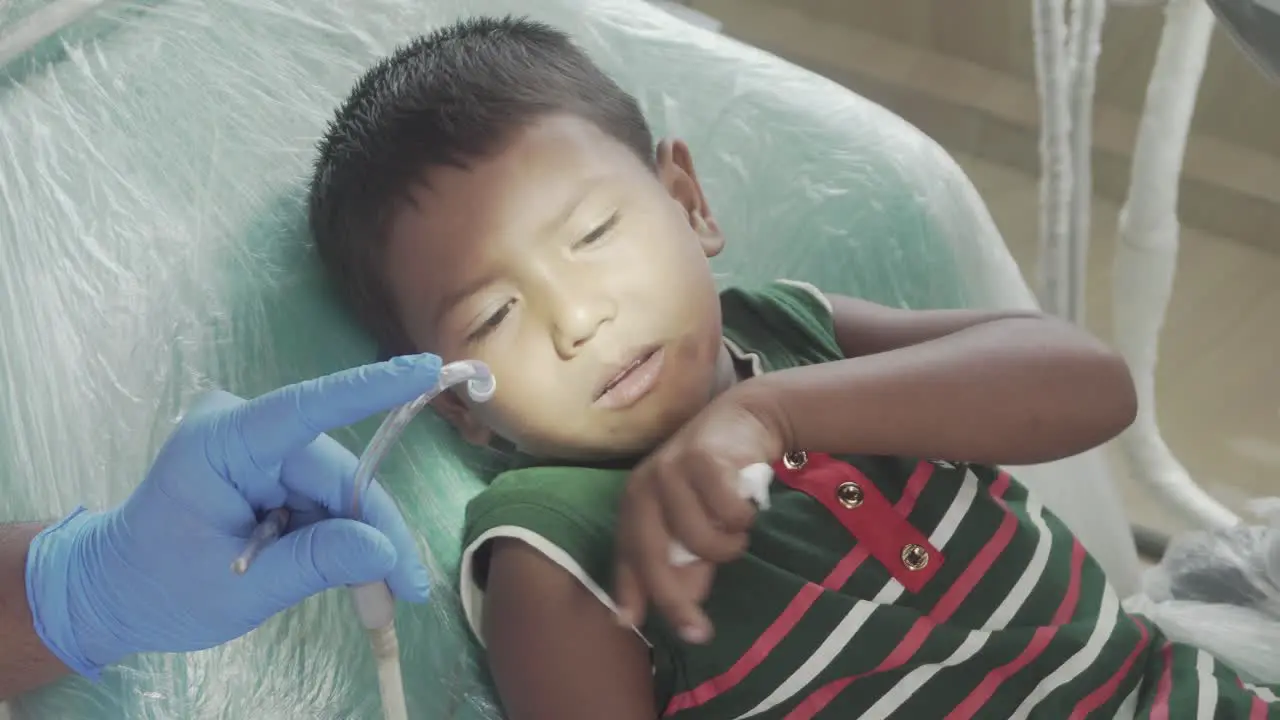 Young dentist is working on a children in his office