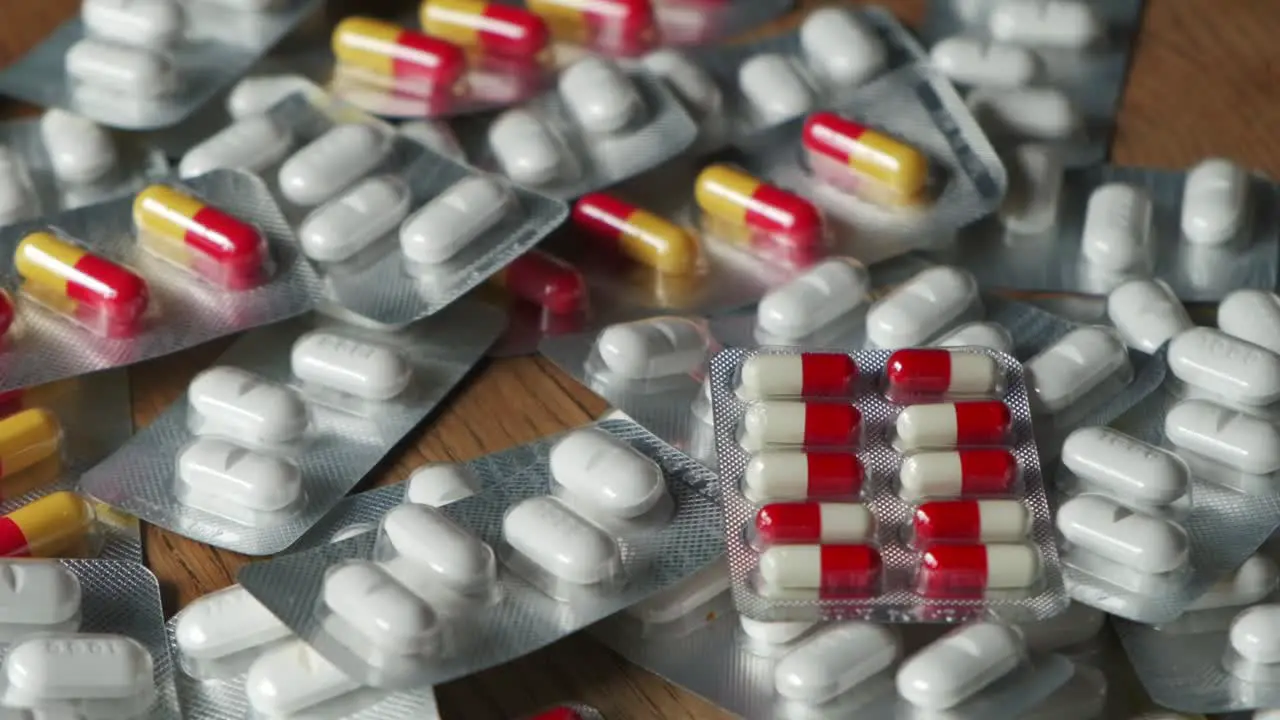 Colorful medication pills tablets closeup 100fps slow motion