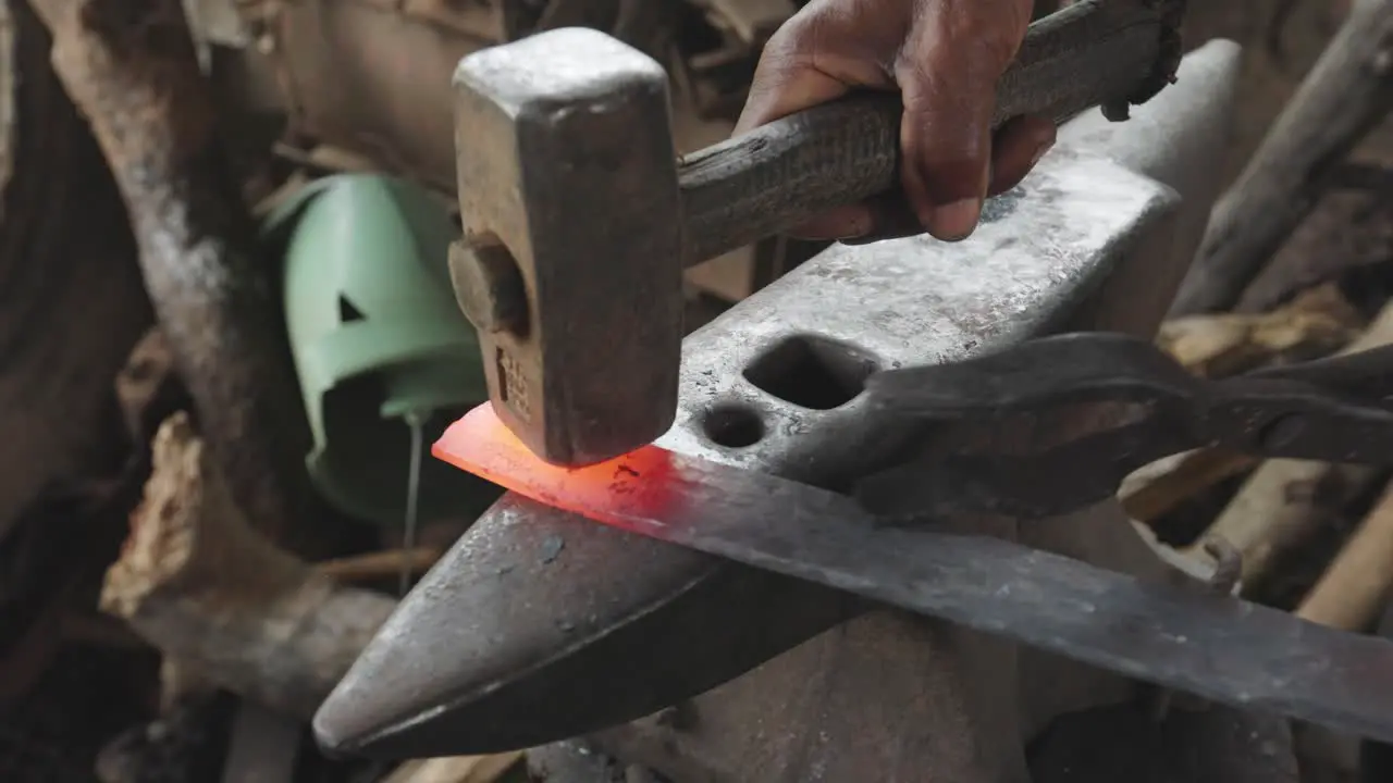 Blacksmith Strikes Hot Metal with Heavy Hammer on Anvil to Shape it