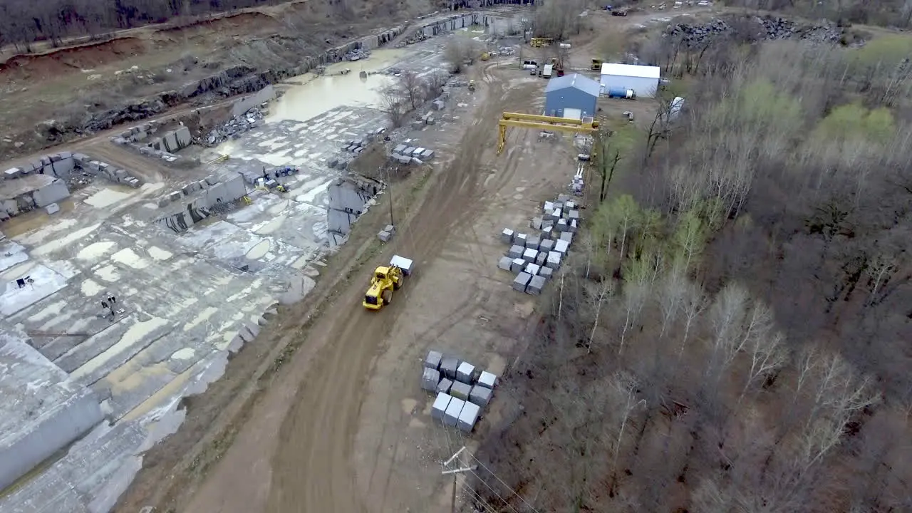 Front Loader Construction Vehicle Moving Massive Block of Granite in Quarry