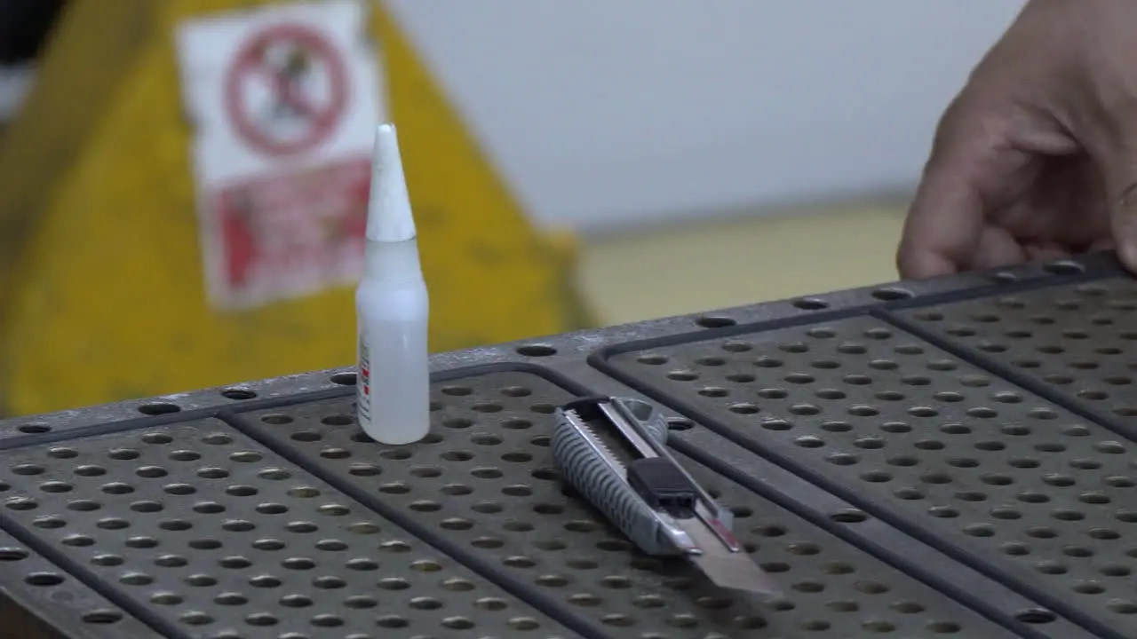 worker glues rubber seals on a metal box