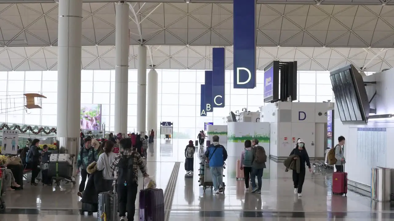 Passengers are seen walking through the airline check-in and departure hall in Hong Kong's Chek Lap Kok International Airport