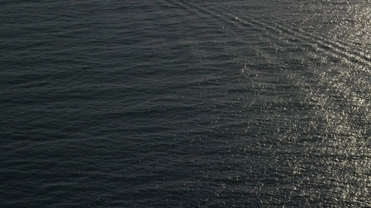 A beautiful aerial shot over a boat heading out to oil derricks and platforms in the Santa Barbara Channel California