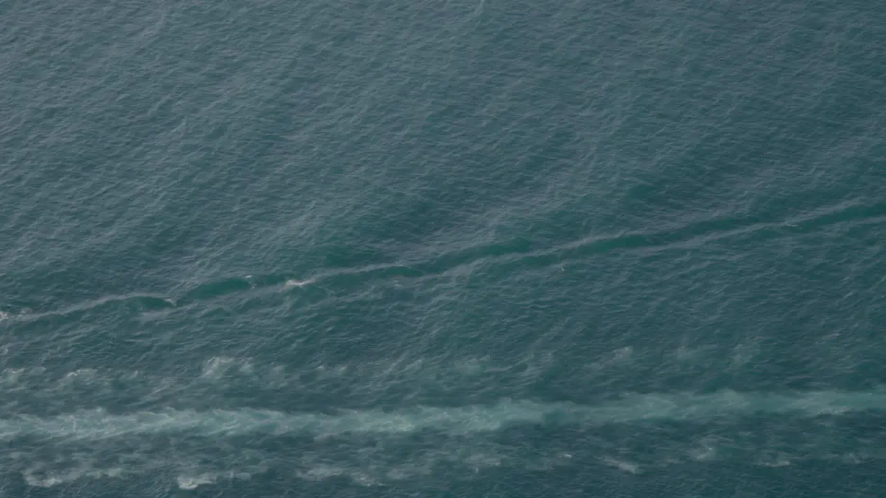 An aerial shot over a boat heading out to oil derricks and platforms in the Santa Barbara Channel California 1