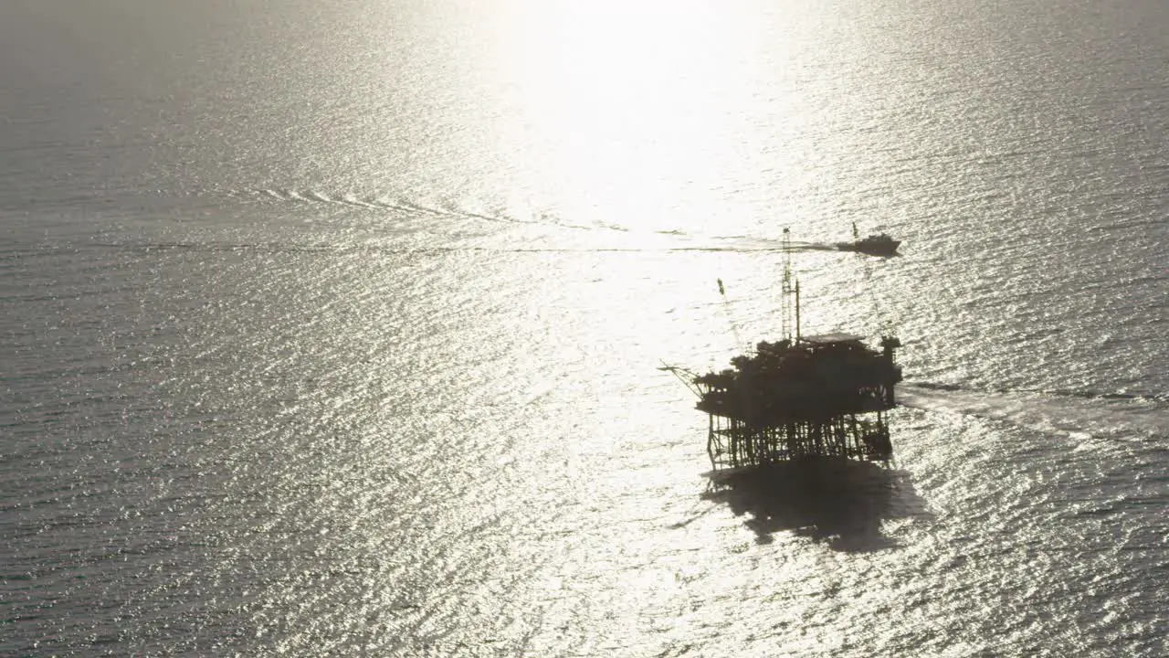 A beautiful aerial shot over a boat heading out to oil derricks and platforms in the Santa Barbara Channel California 1