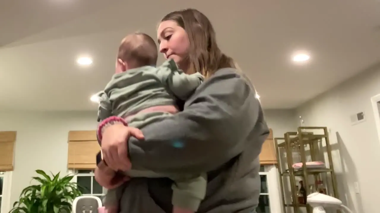 Young Female Babysitter Holding Bouncing And Playing With Small Baby By putting up in the Air