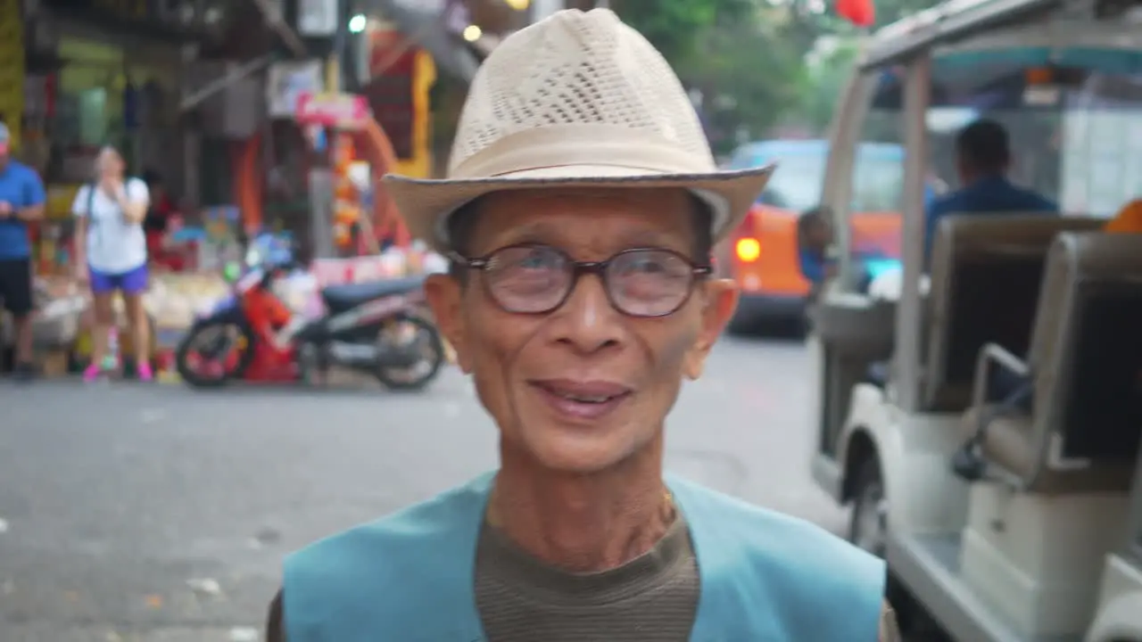 Old working man walking through the streets of Hanoi Vietnam