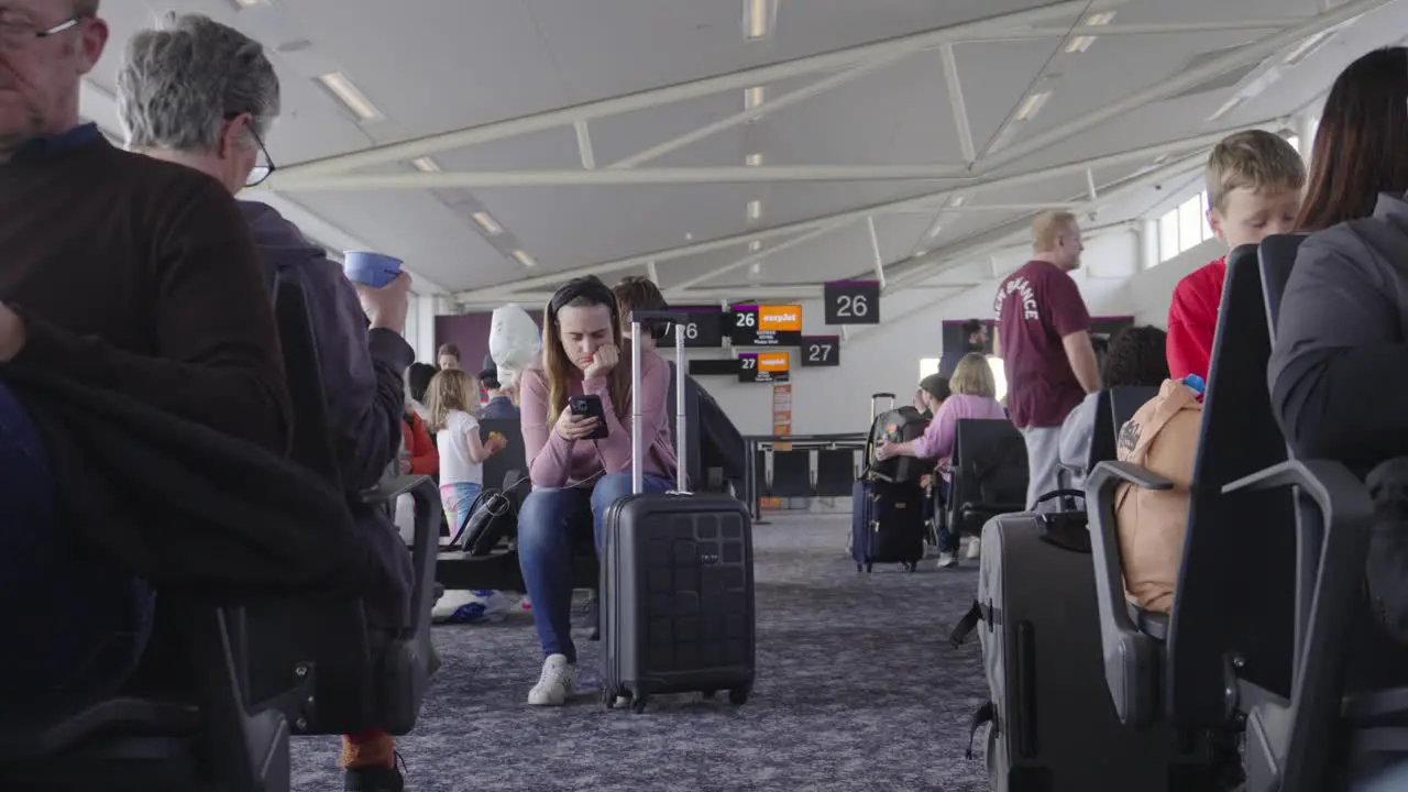 Passengers keep themselves entertained while waiting for flight to be announced