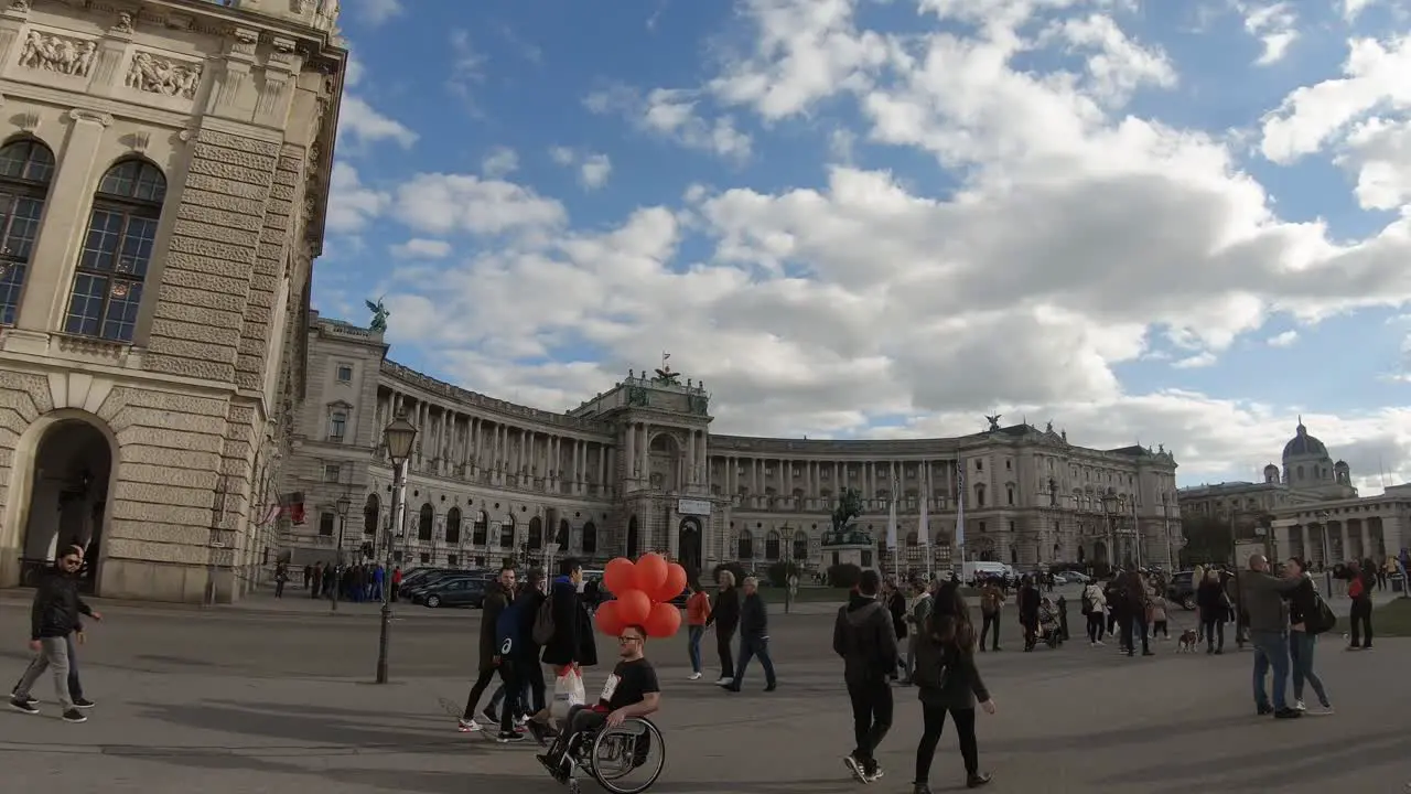 Man on a wheelchair with orange ballons in Vienna