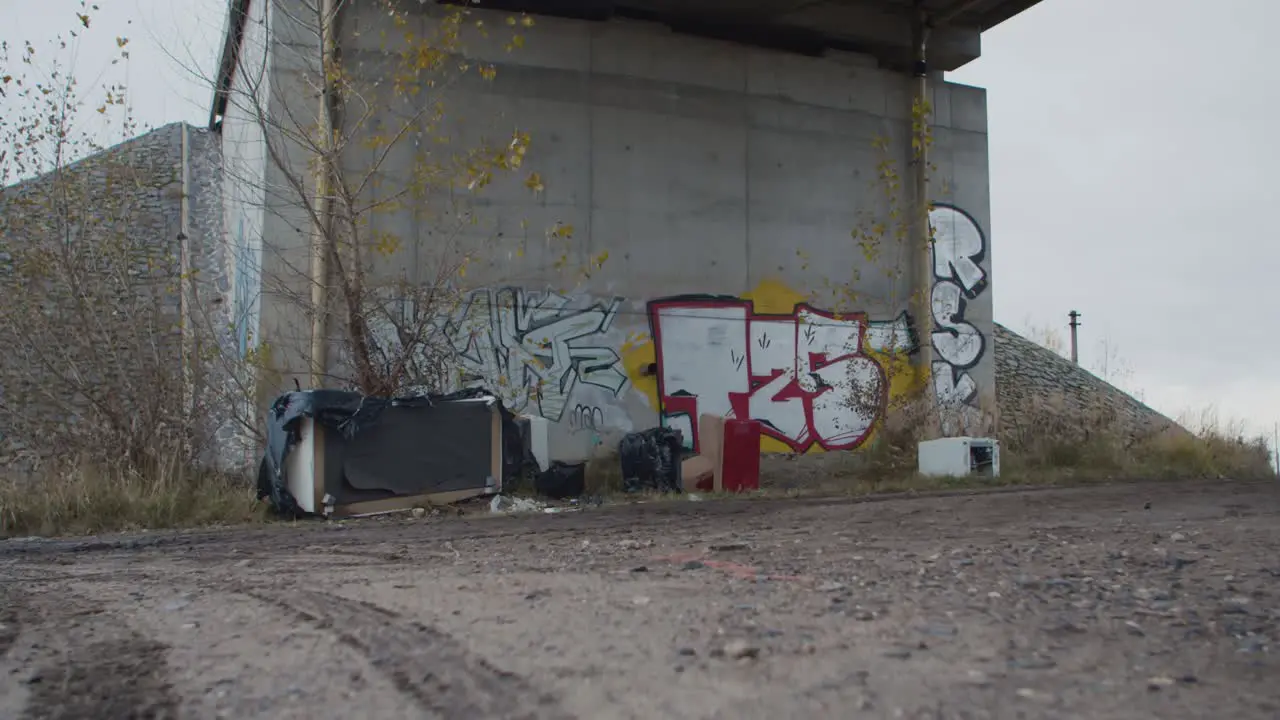 Old unnecessary furniture and a lot of rubbish dumped under the bridge