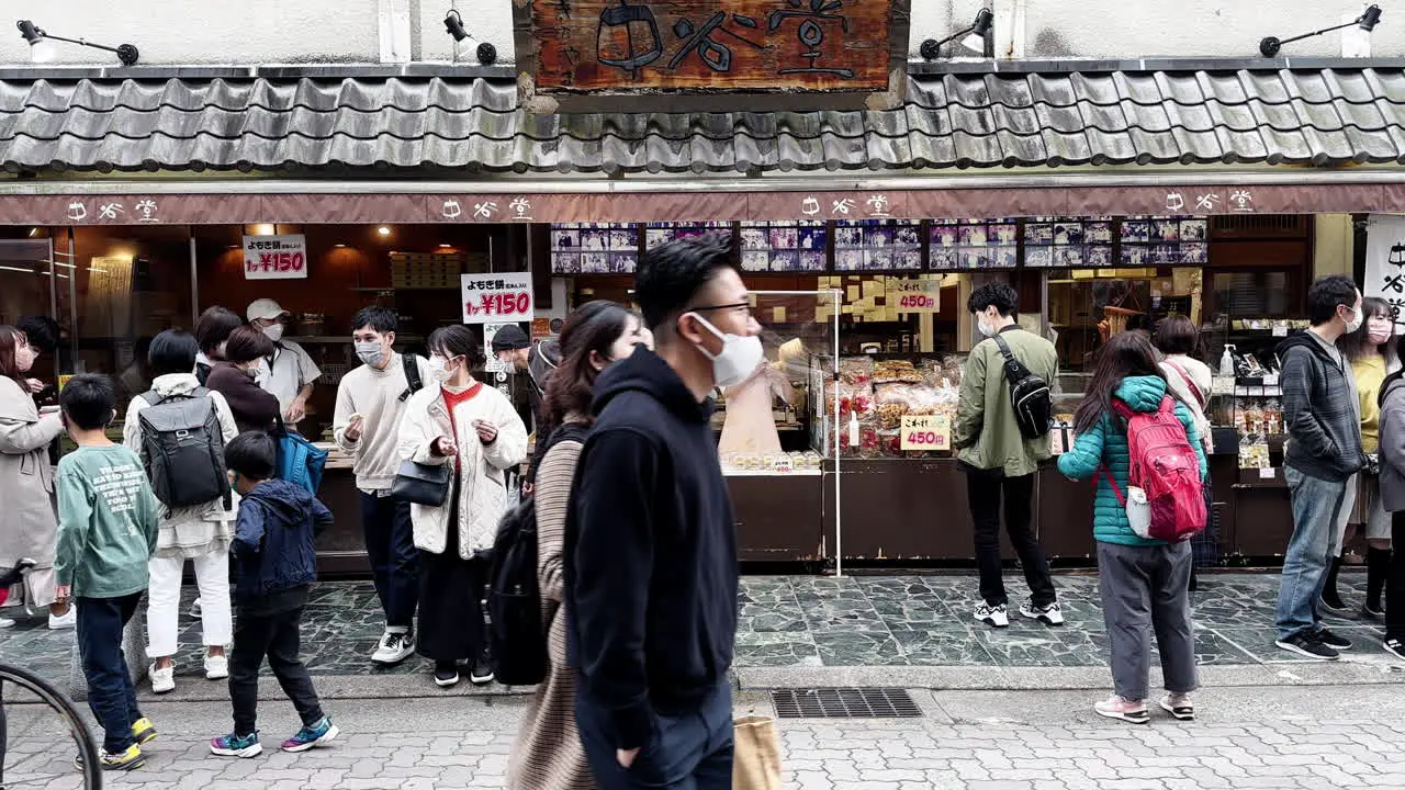 People with face masks on crowded food market street in Nara Japan