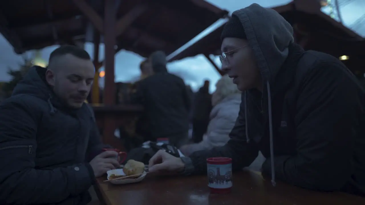 2 guys are having a conversation on a Christmasmarket