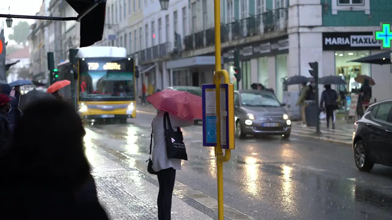 People waiting for bus at bus stop on a rainy day