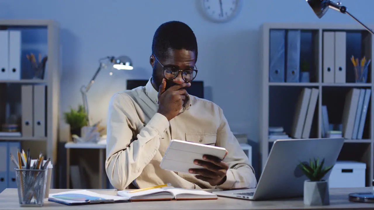 Close Up View Of Businessman In Glasses Watching Something On The Tablet And Taping On Hte Screen In The Office At Night 1