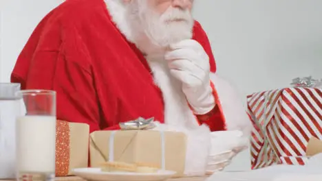 Medium Shot of Santa Sitting at Desk Preparing Gift