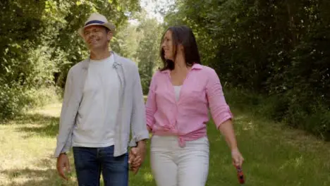 Tracking Profile Shot of Middle Aged Couple Walking In Scenic Woodland