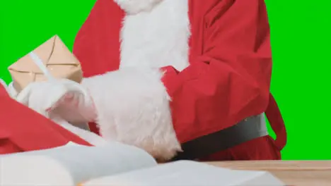 Close Up Shot of Santa Placing Gifts In a Big Red Sack