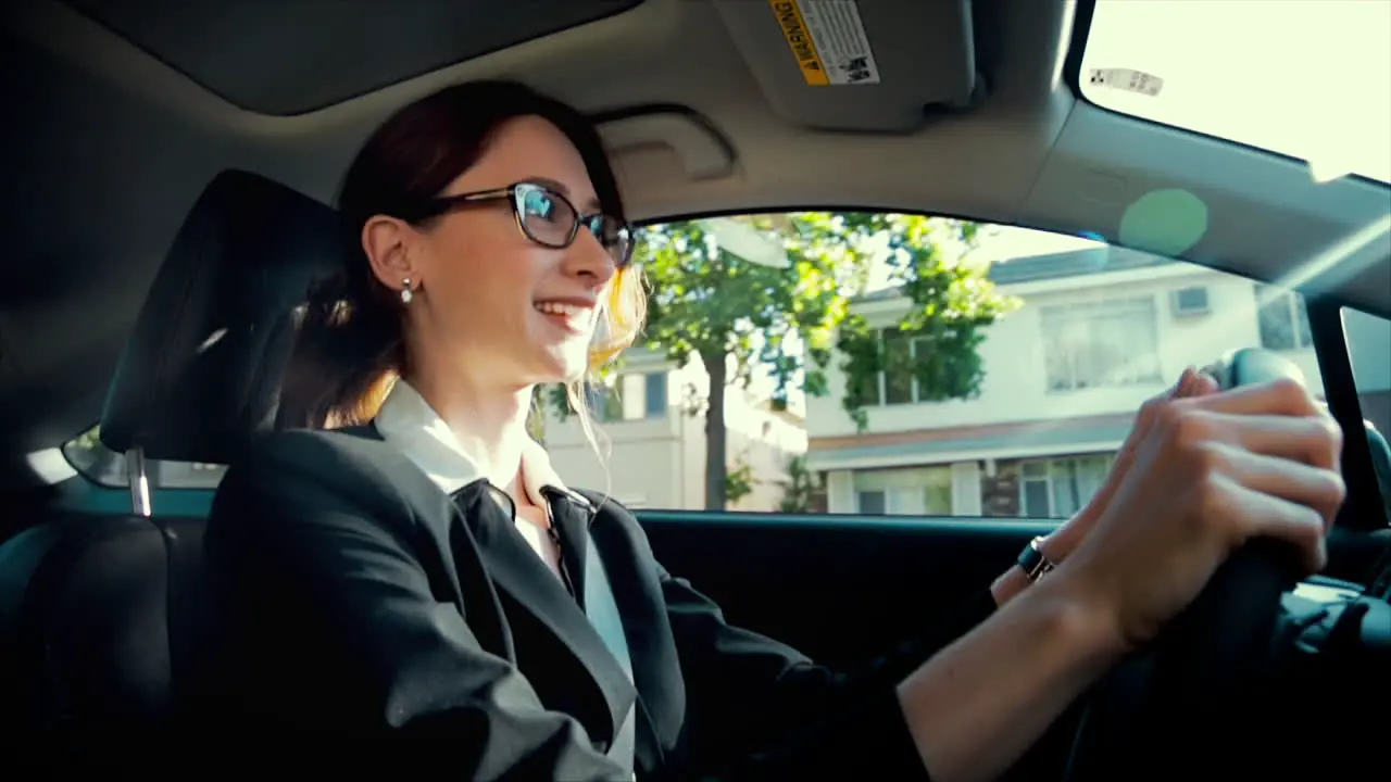 Business woman driving while smiling and laughing