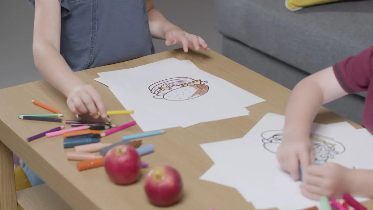 Close Up Of Two Children At Home Colouring In Picture At Table 1