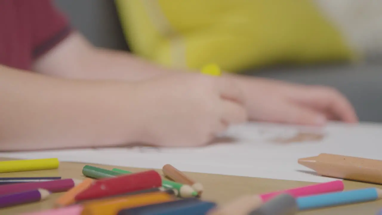 Close Up Of Child At Home Colouring In Picture Of Food At Table