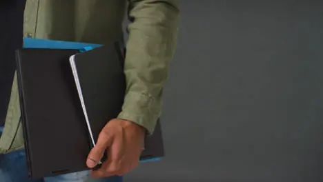 Close Up Shot of Mans Hand Holding Folder and Book