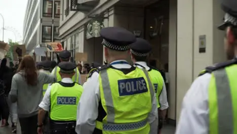 London Police Officers Walking Amongst Protesters Chanting