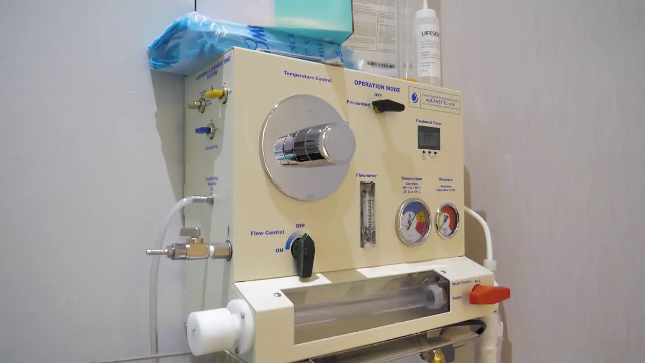 Slow motion tilting shot of a colon hydrotherapy machine in a clinic room