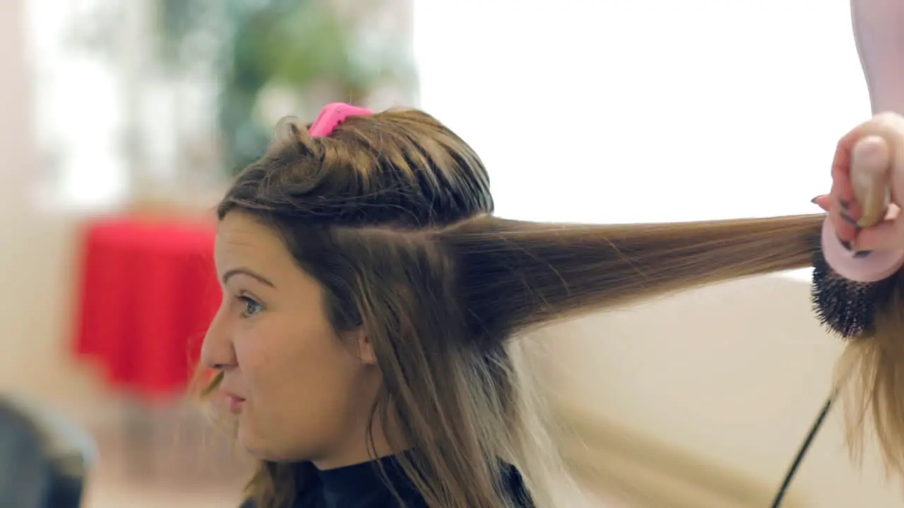 Young woman talking to her hair stylist at the salon