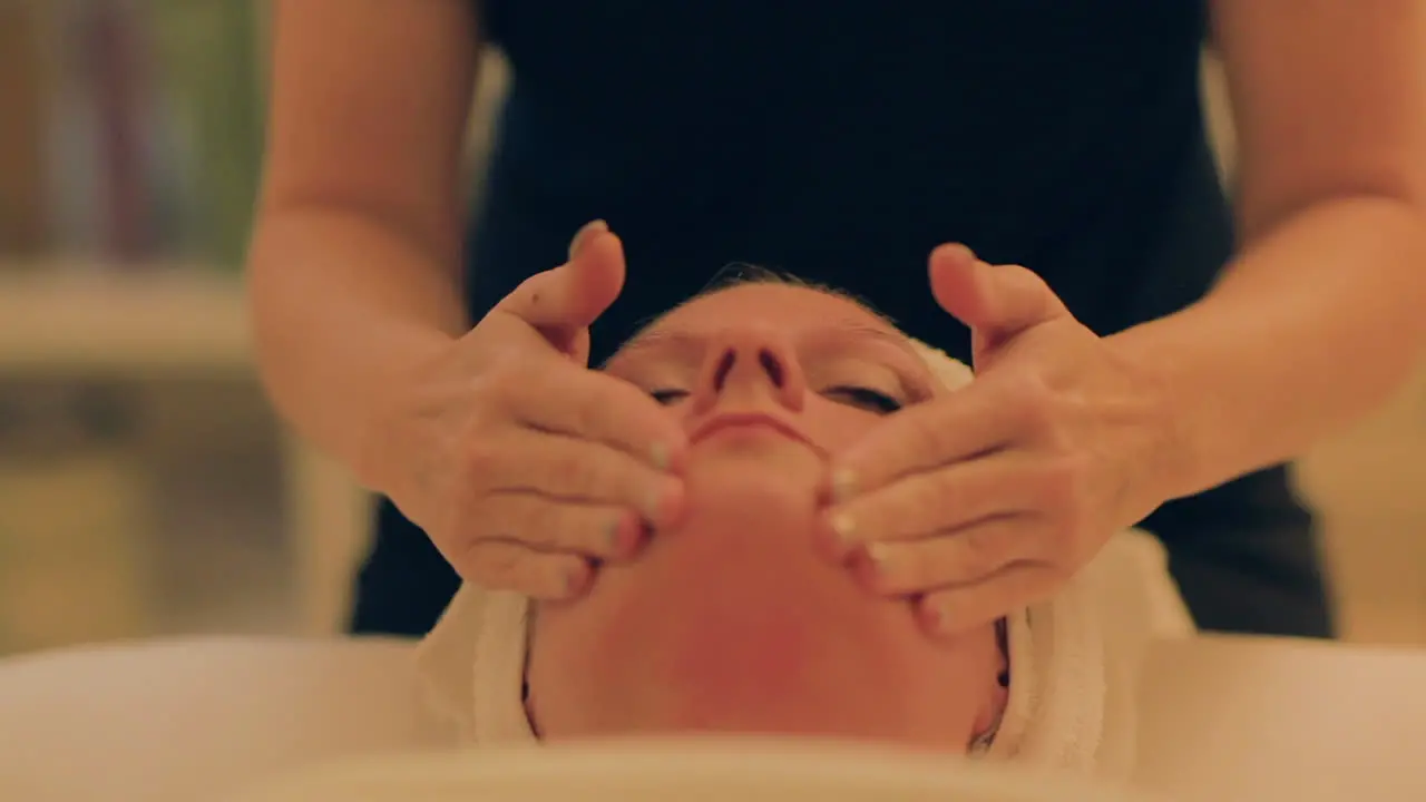 Beautiful woman getting her face massaged at the spa