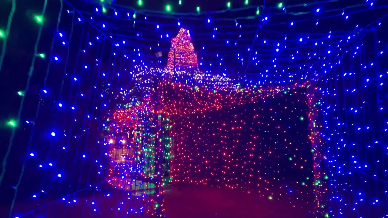 Exiting tunnel of thousands of Christmas lights at night