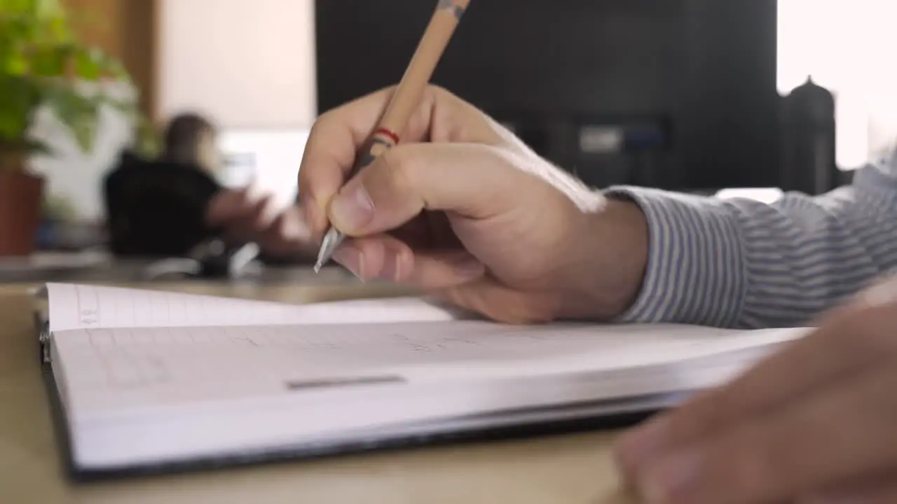 Man handwriting in an office making business plans