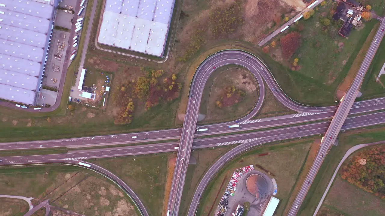 Aerial Shot of Industrial Warehouse Storage Building Loading Area where Many Trucks Are Loading Unloading Merchandise