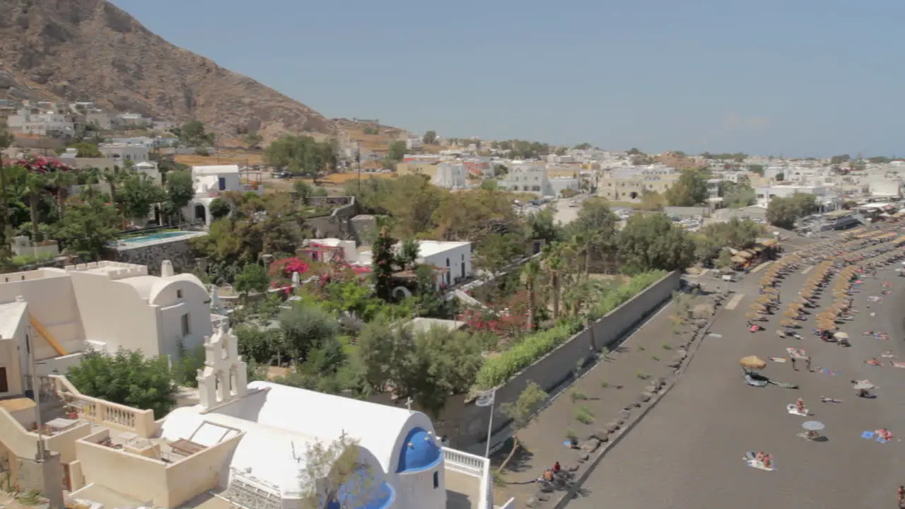 Slow panning shot from a high angle of the black peddle beach of Kamari on the island of Santorini