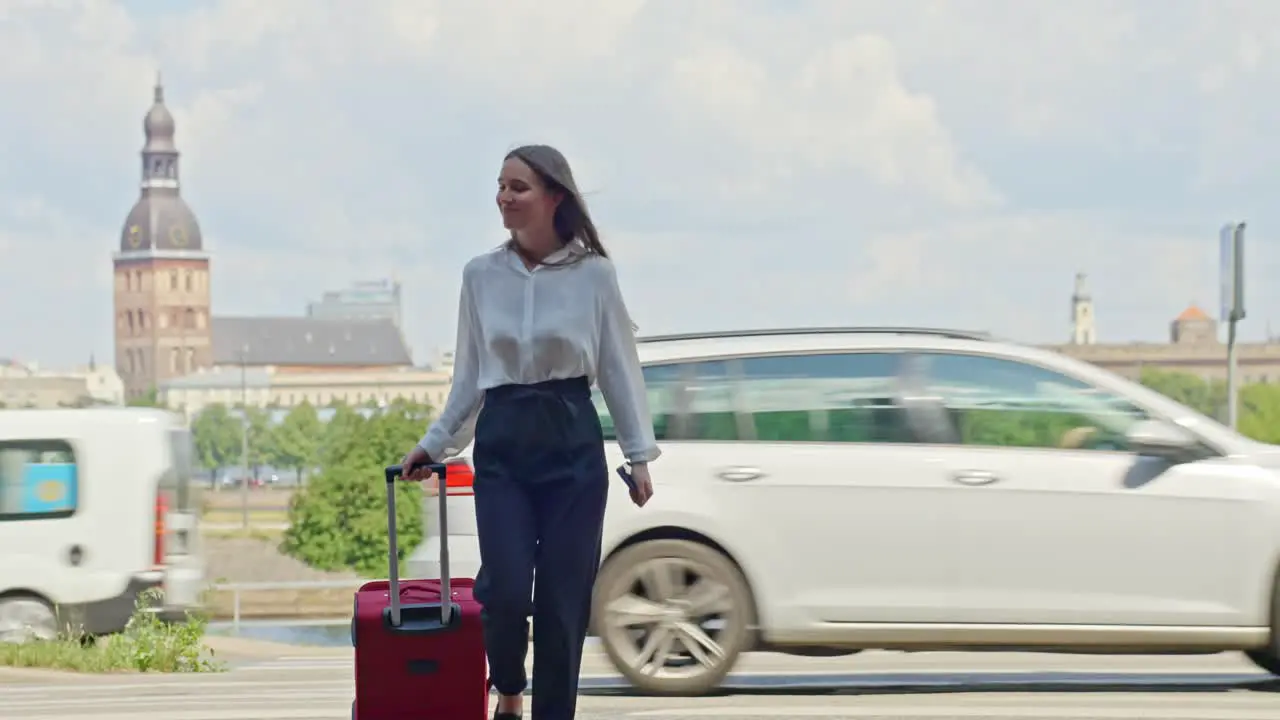 Business woman pulling her suitcase on business trip in front of Riga Cathedral