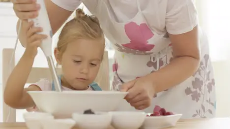 Serious pretty little girl concentrating on baking