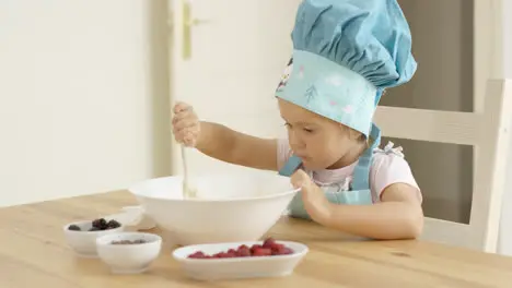 Adorable smiling toddler at mixing bowl