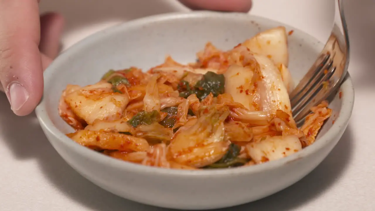 A tasty bowl of kombucha stir fry is eaten with a fork