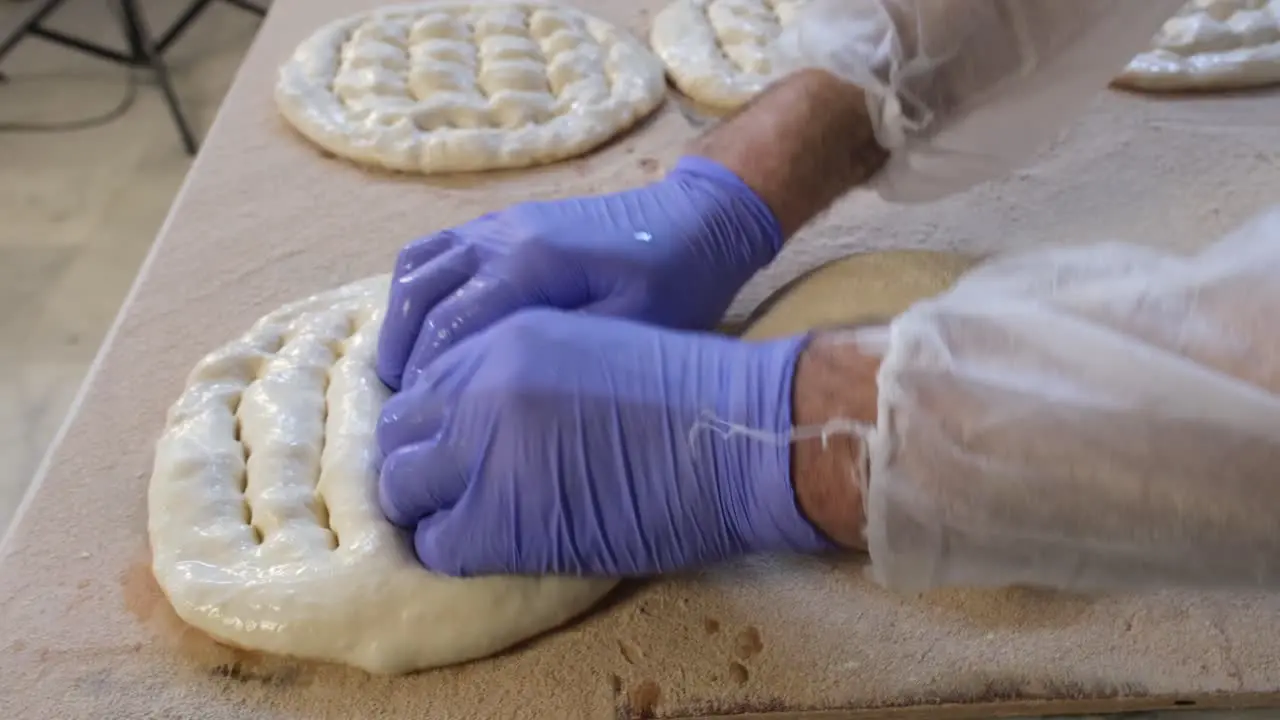 baker shapes the pita dough