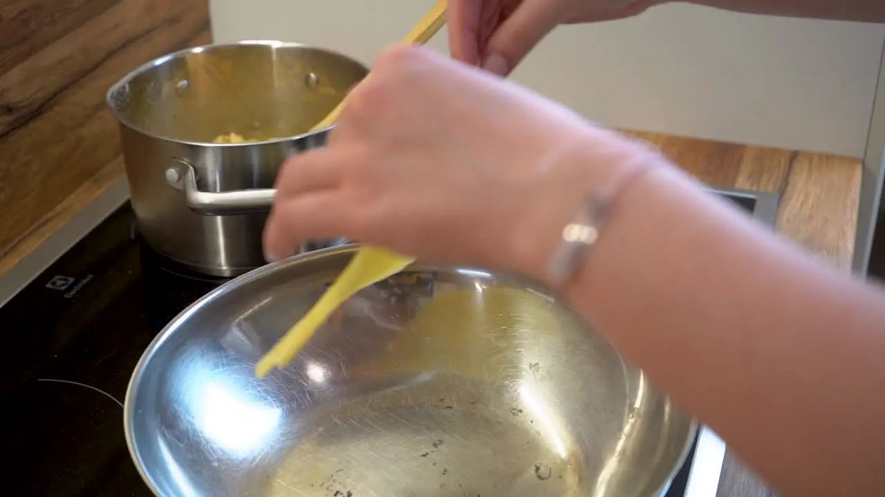 Woman's Hand Putting a Slice of Tortilla Dough in a Frying Pan