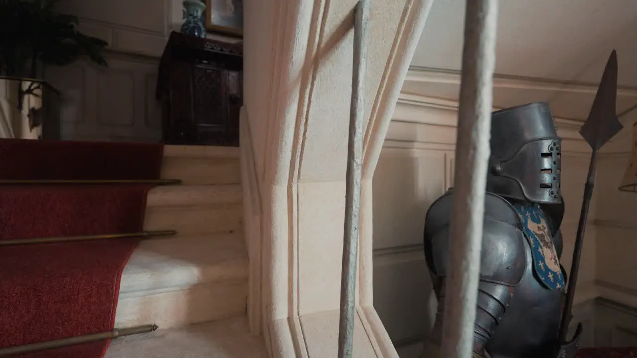 Scenic Stairway in big french architectural Castle with a historic knight outfit as decoration in the hallway