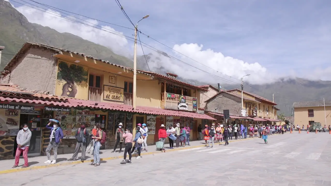 A group of women lined up 6 feet apart in Plaza de Armas to enter the market during the pandemic in Ollantaytambo Peru