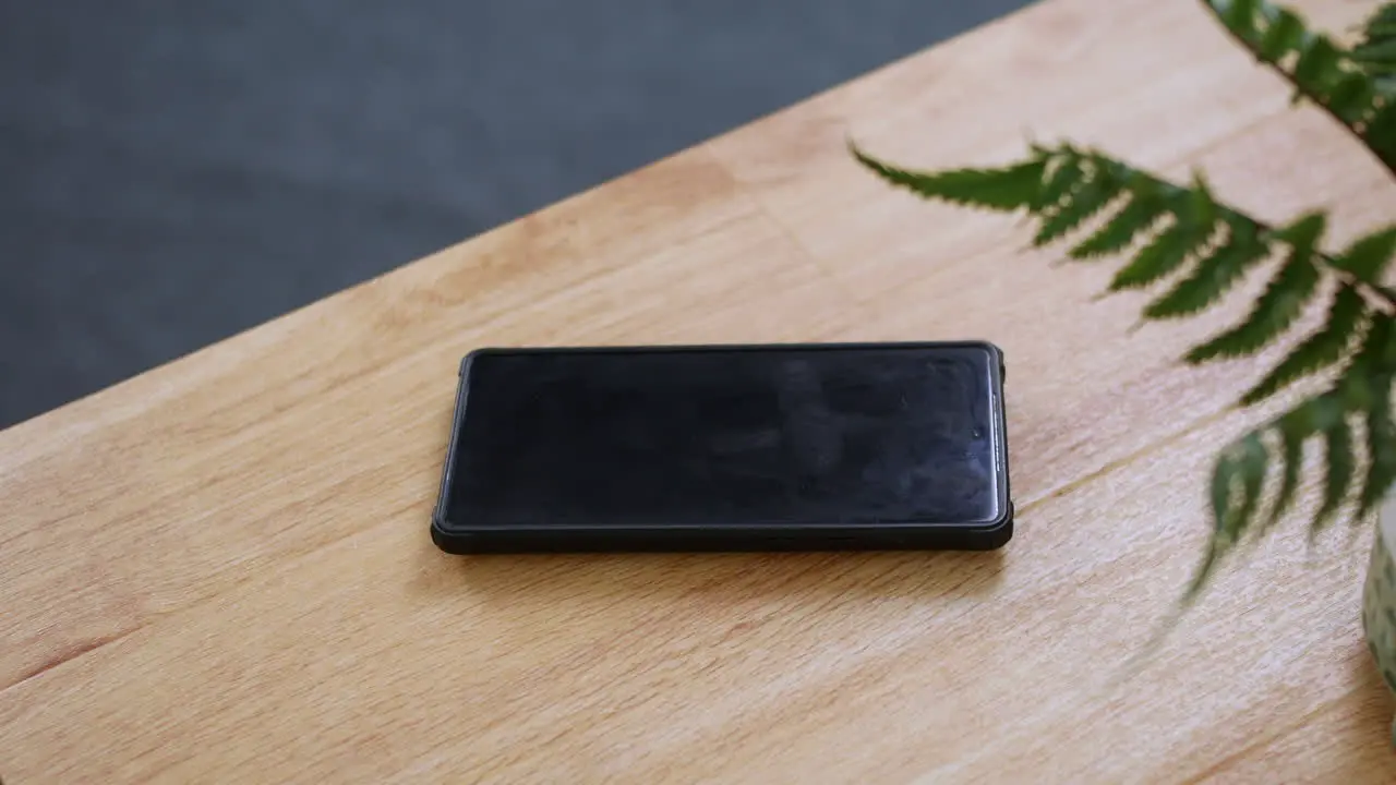 A phone ringing on a wooden desk table