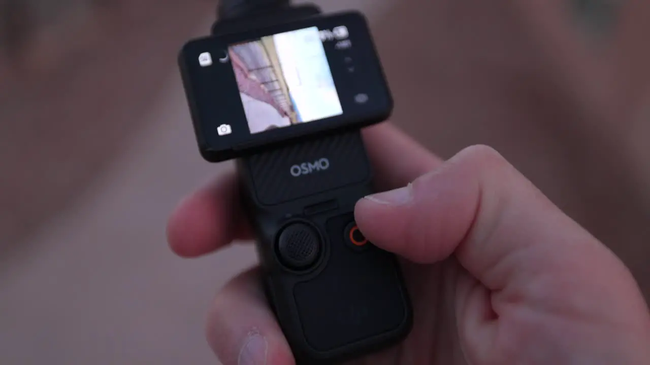 Close Up View Of DJI Osmo Pocket 3 Held In Hand And Screen Being Flipped From Vertical To Landscape Mode