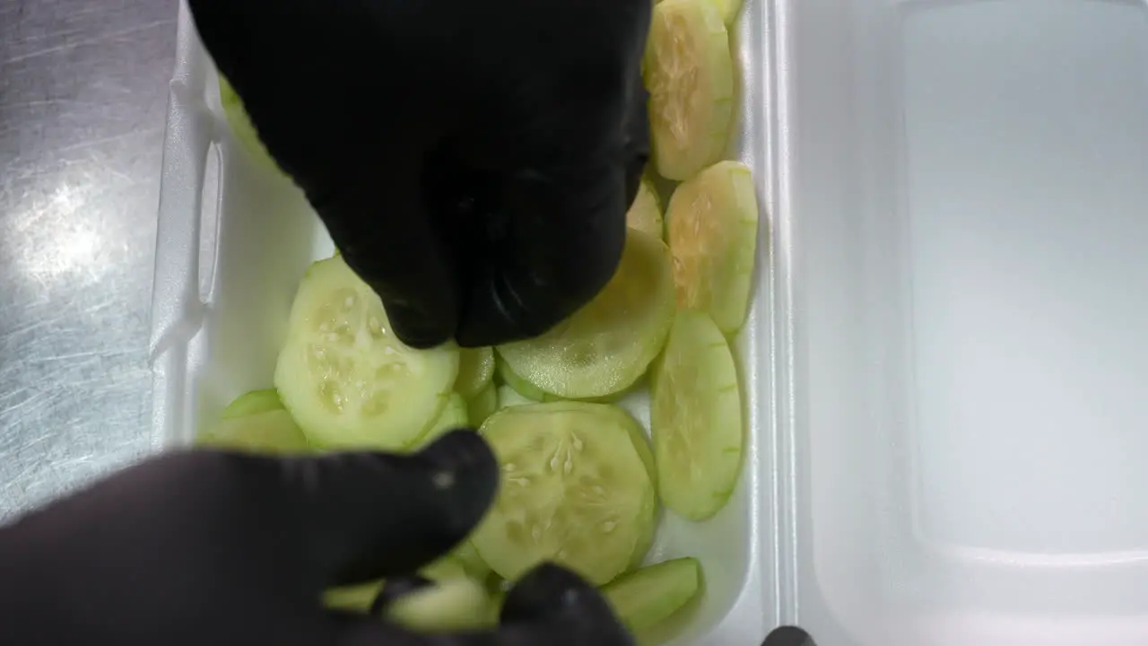 Lining a take out bowl with cucumber slices for a keto bowl order food truck series